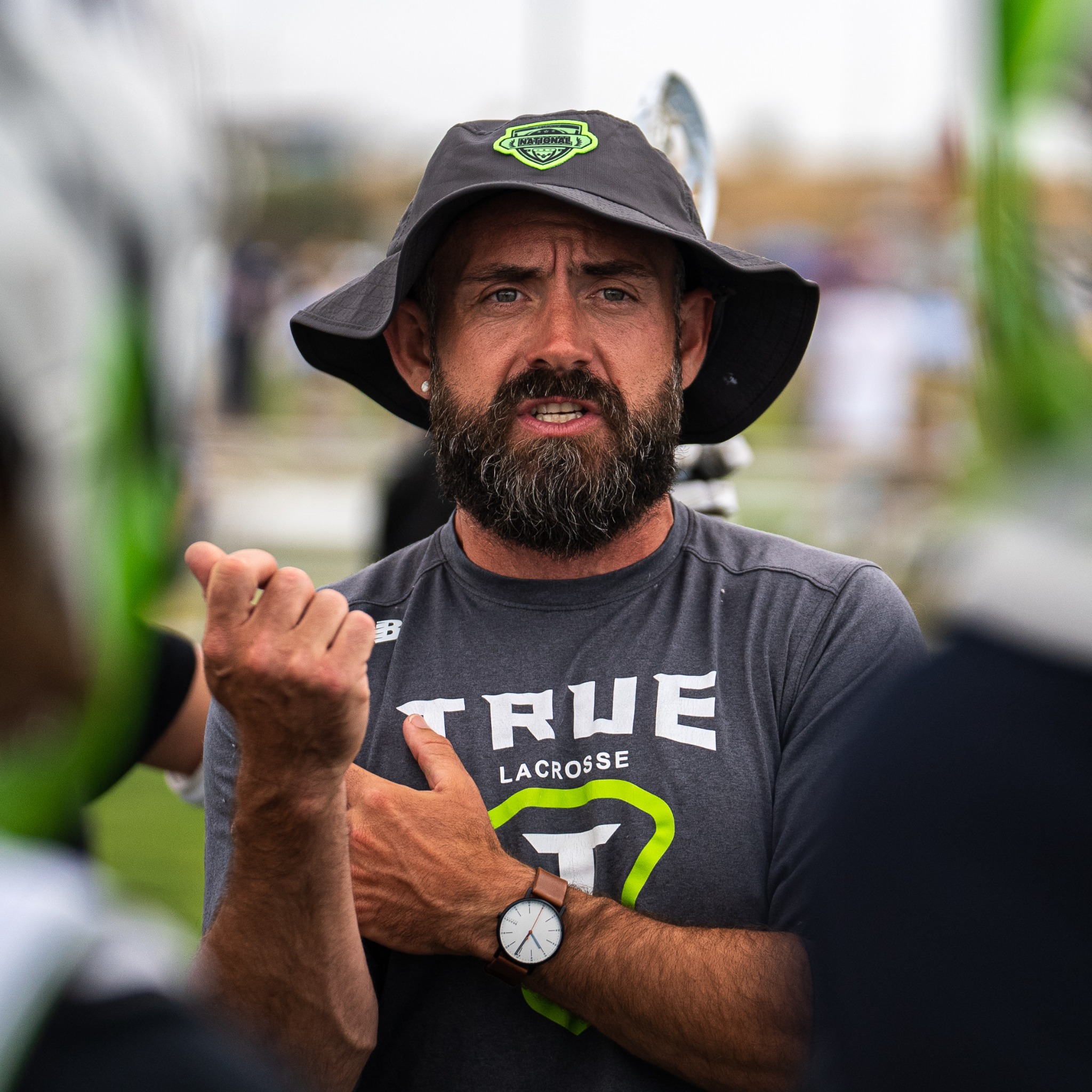 PJ Martin speaking and gesturing while coaching at a lacrosse event